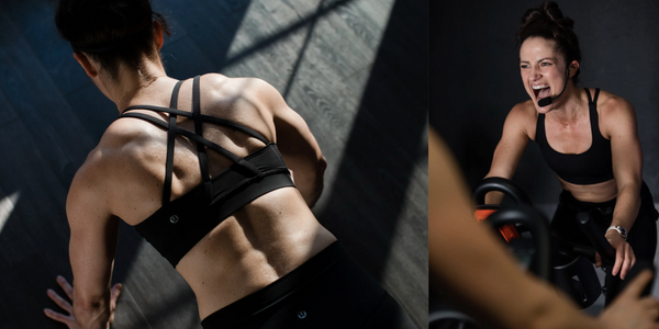 A woman cycling intensely on a stationary bike shows the kind of sweat-heavy training session where hydration timing before, during, and after exercise makes the biggest difference.