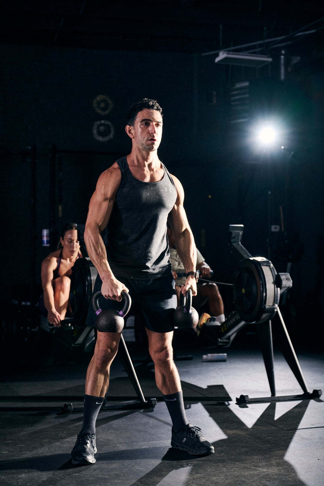 Man holding two kettlebells in the gym