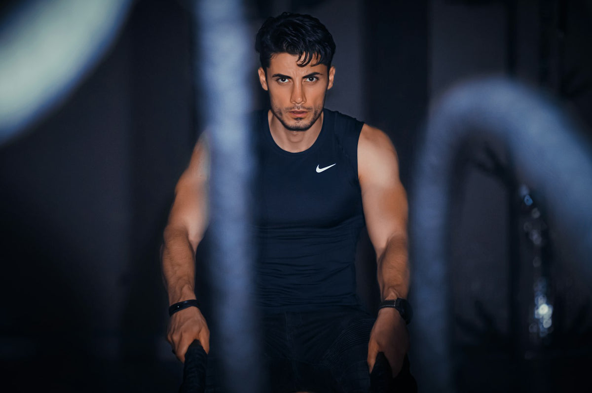 A muscular man drenched in sweat during an intense workout, illustrating how much sodium the body loses through sweat during exercise.