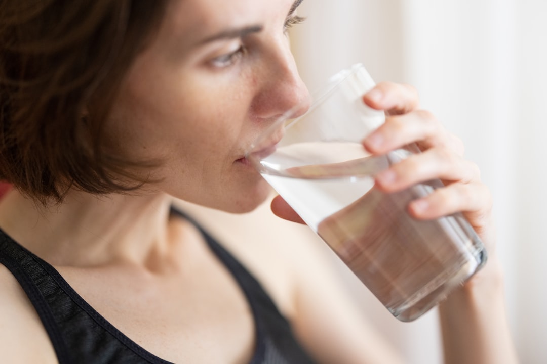 Woman drinking a glass of water during a workout