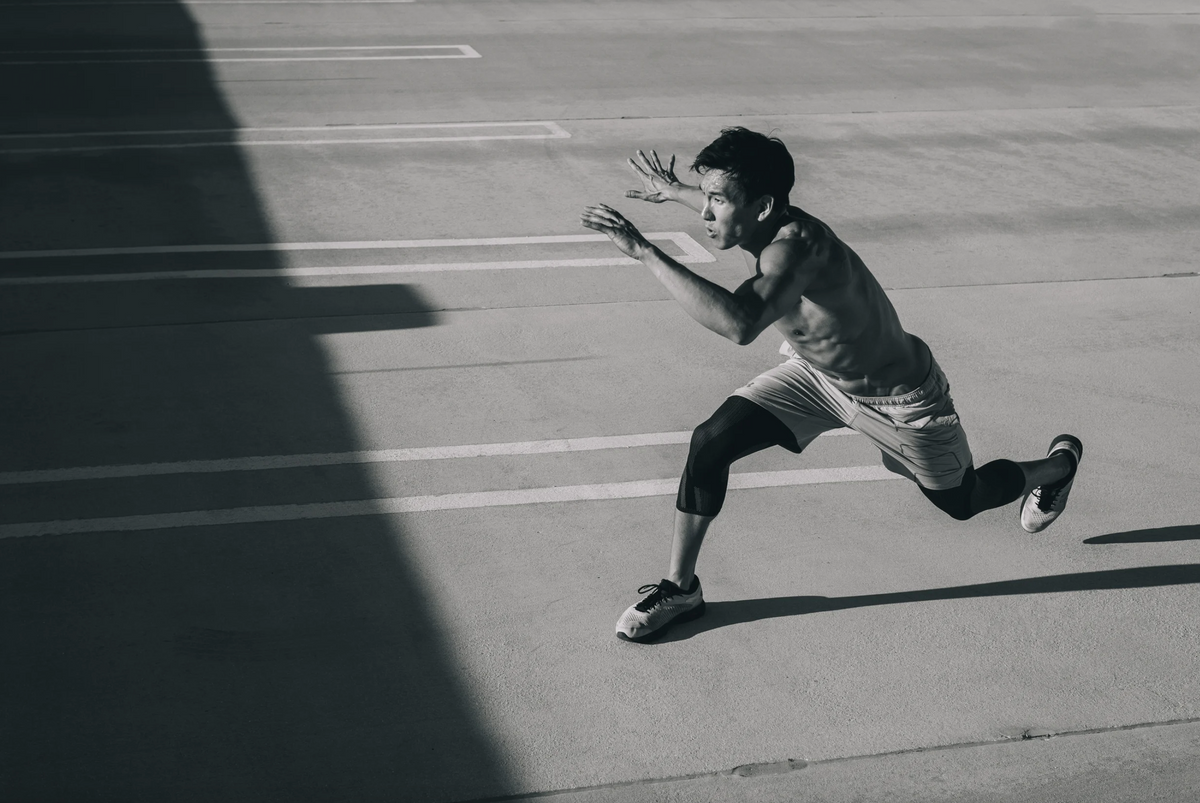 A runner sprints down an outdoor track, the kind of high-intensity training that drives up sodium and potassium electrolyte losses through sweat.
