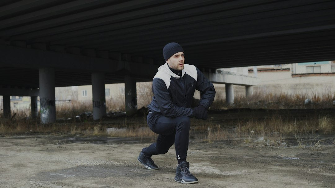 A runner stretches his calf outdoors after training, illustrating how electrolytes help prevent exercise-associated muscle cramps.