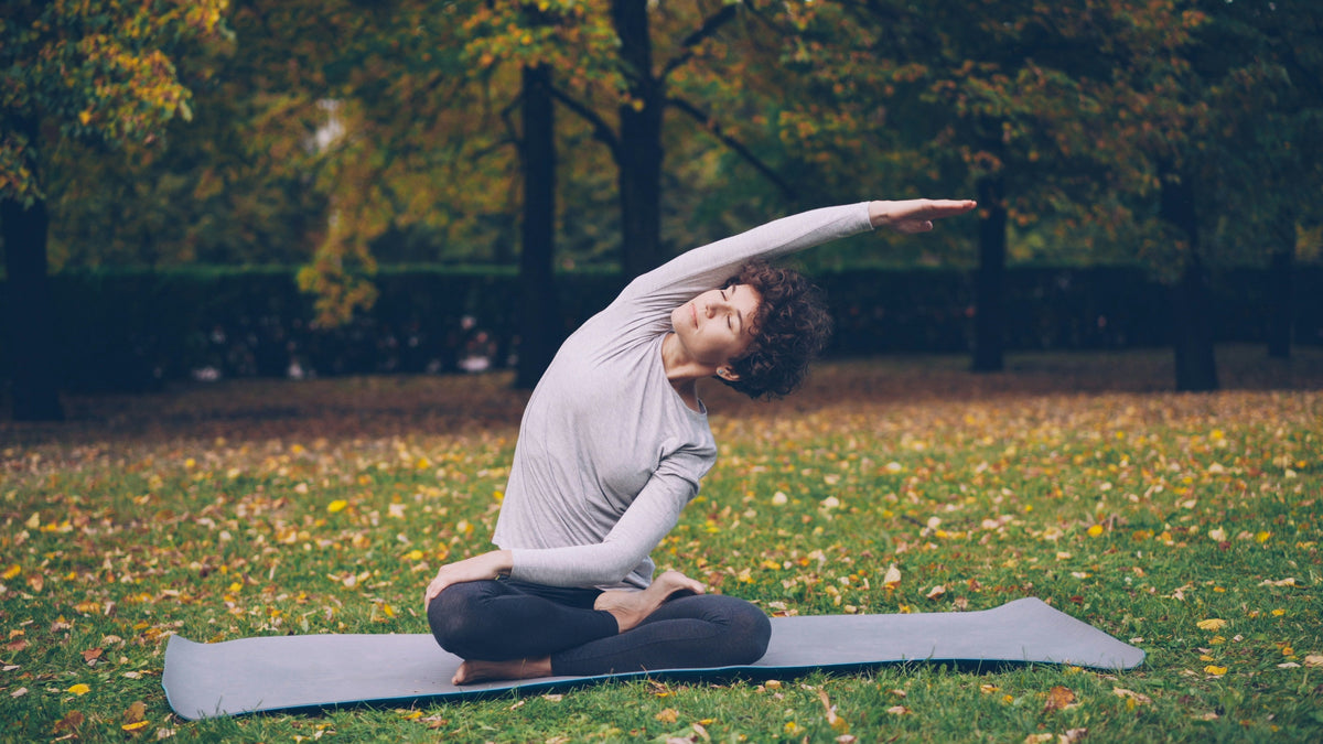 A woman stretches calmly outdoors, representing the brain clarity and calm focus new research links to creatine during menopause.