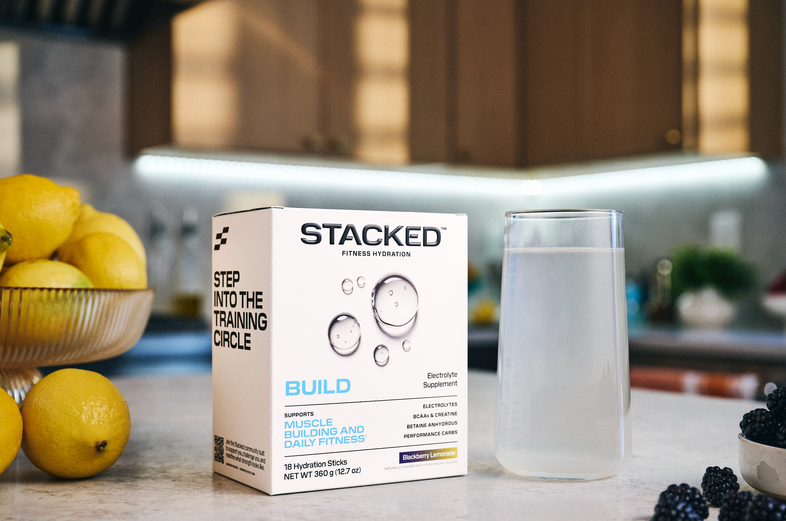 Stacked fitness hydration box on a kitchen counter with lemons and a glass of water.