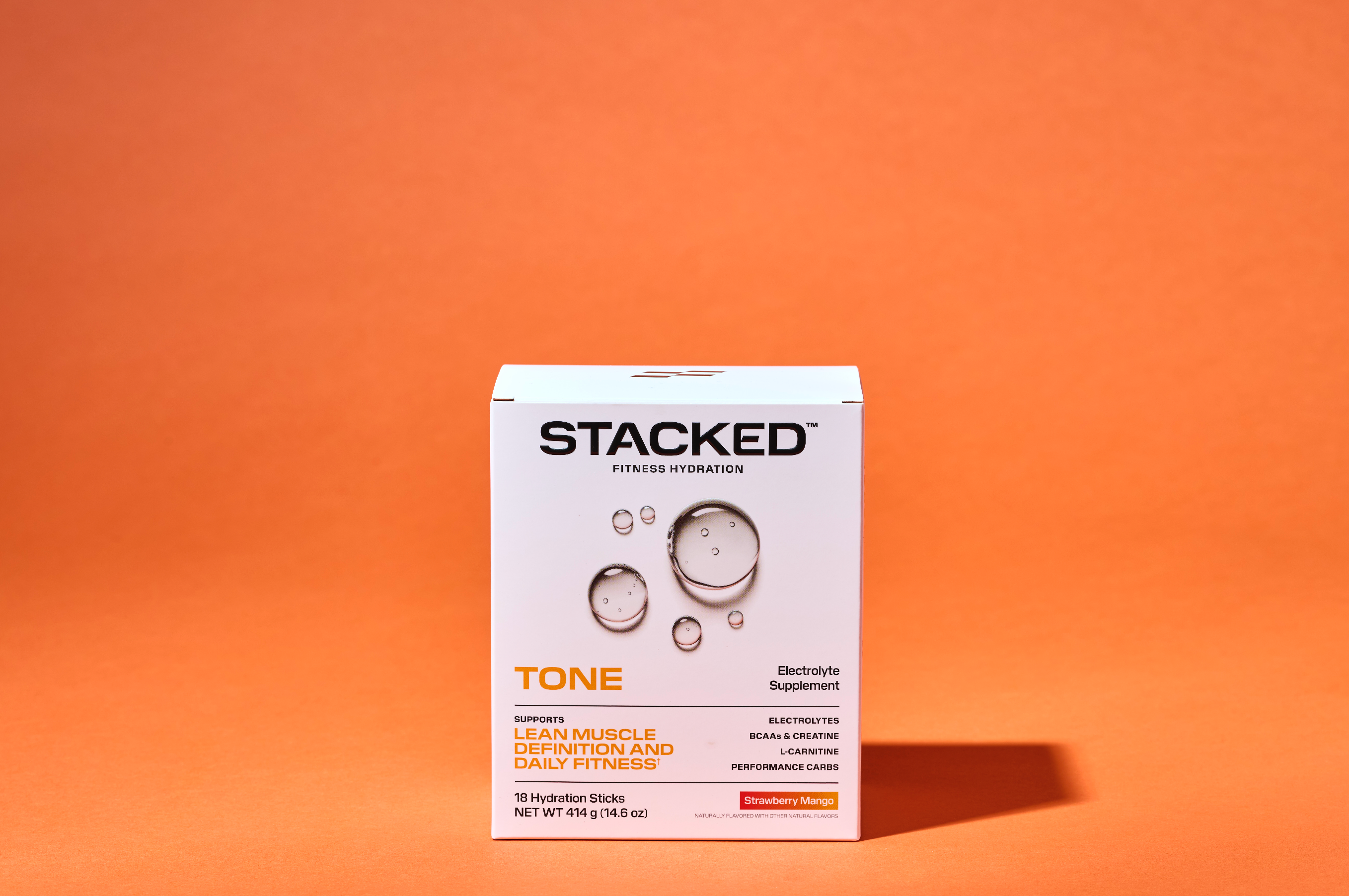 Stacked Tone supplement box on an orange background