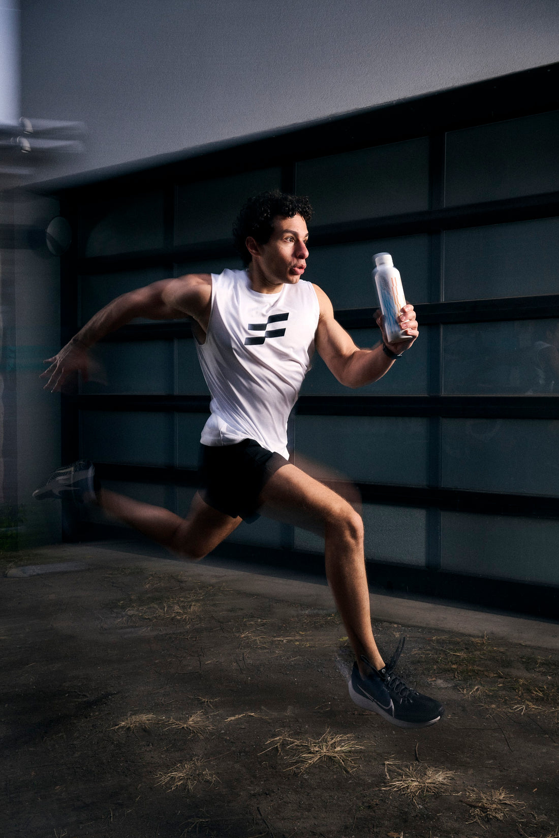 Man sprinting with a Stacked water bottle in hand