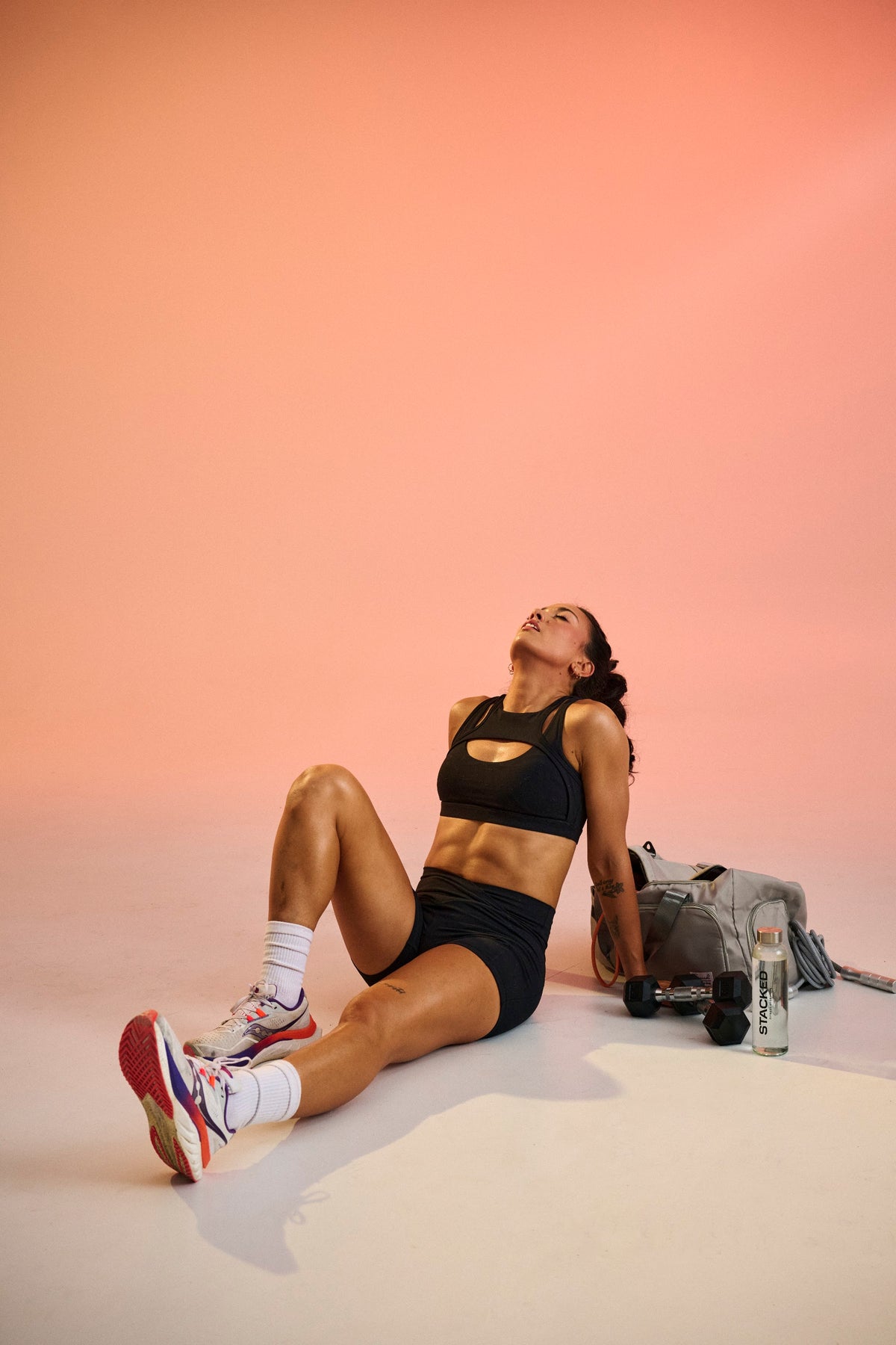 Woman resting on the floor after a workout with her water bottle nearby